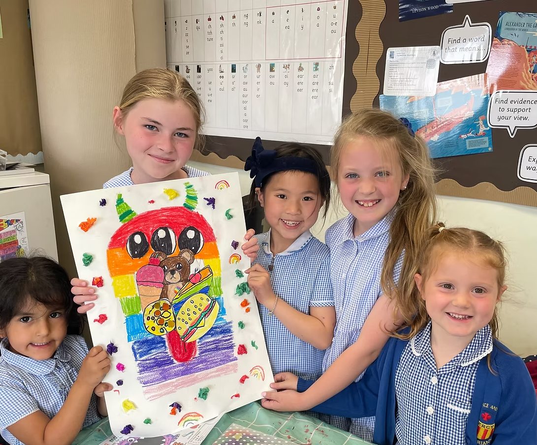 Children at The Art Hut holding up a colourful collage