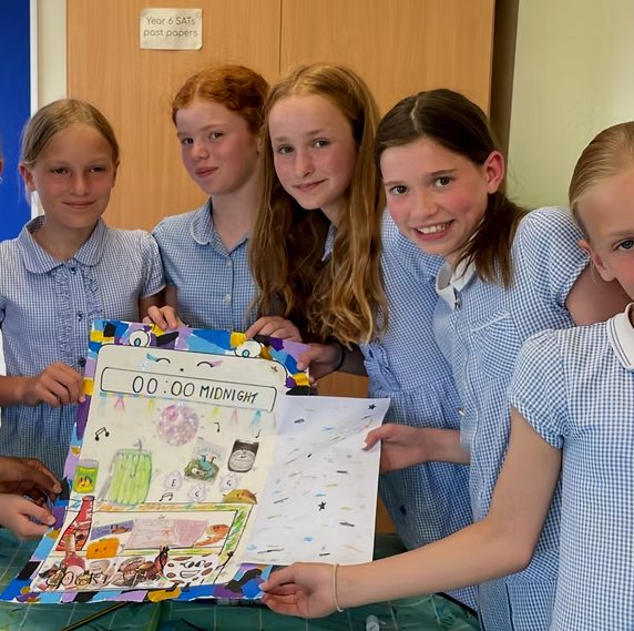 Pupils holding up a group artwork
